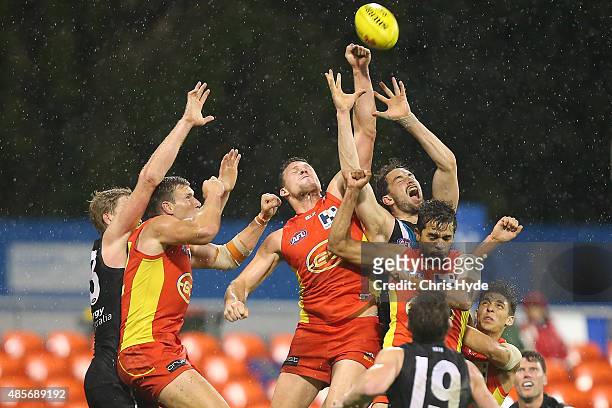 Players compete for a mark during the round 22 AFL match between the Gold Coast Suns and the Port Adelaide Power at Metricon Stadium on August 29,...