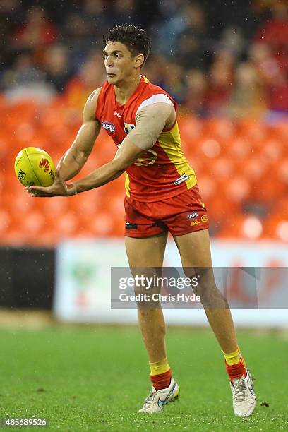 Sean Lemmens of the Suns handballs during the round 22 AFL match between the Gold Coast Suns and the Port Adelaide Power at Metricon Stadium on...