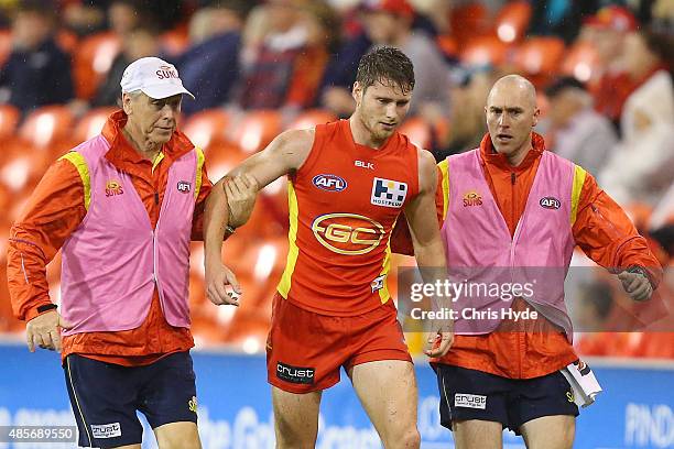 Clay Cameron of the Suns leaves the field injured during the round 22 AFL match between the Gold Coast Suns and the Port Adelaide Power at Metricon...