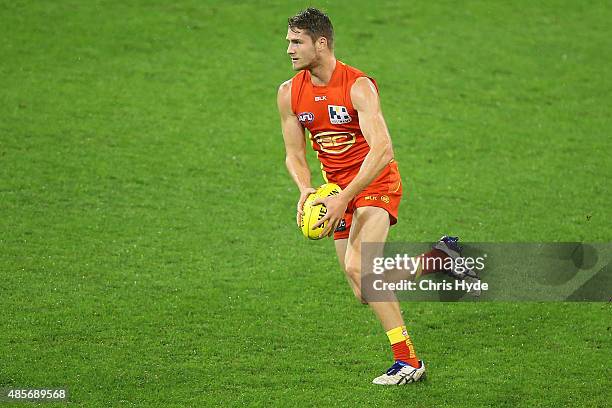 Clay Cameron of the Suns runs the ball during the round 22 AFL match between the Gold Coast Suns and the Port Adelaide Power at Metricon Stadium on...