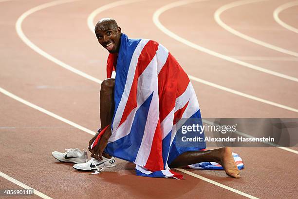 Mohamed Farah of Great Britain celebrates after crossing the finish line to win gold in the Men's 5000 metres final during day eight of the 15th IAAF...