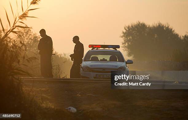 The sun rises as Hungarian police patrol the border from Serbia into Hungary close to the village of Roszke on August 29, 2015 near Szeged, Hungary....