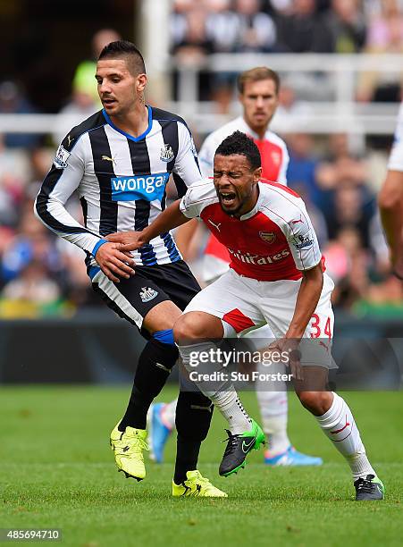 Aleksandar Mitrovic of Newcastle United fouls Francis Coquelin of Arsenal resulting in the red card during the Barclays Premier League match between...