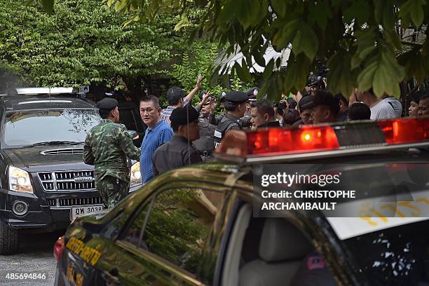 Policemen take away a suspect in the August 17 Bangkok shrine bombing at a compound in a Bangkok suburb on August 29, 2015. Thai authorities on...