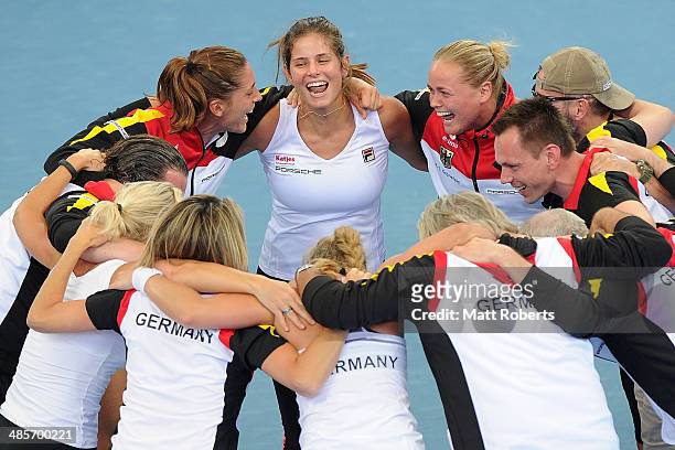 Anna Petkovic, Julia Goerges and Anna-Lena Groenefeld of Germany celebrate victory with team-mates during the Fed Cup Semi Final tie between...