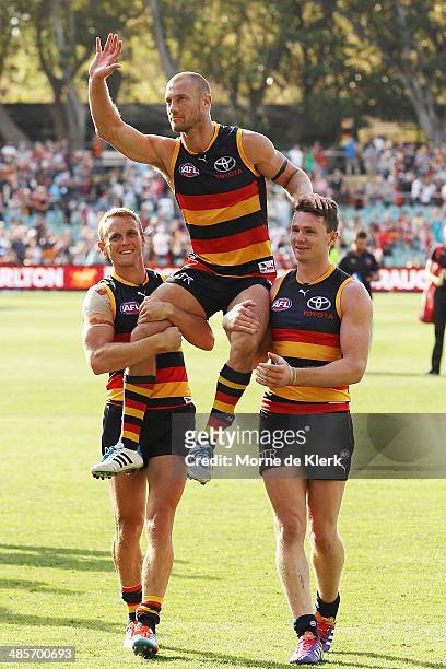 Brent Reilly and Patrick Dangerfield of the Crows carry teammate Scott Thompson from the field after his 250th game during the round five AFL match...