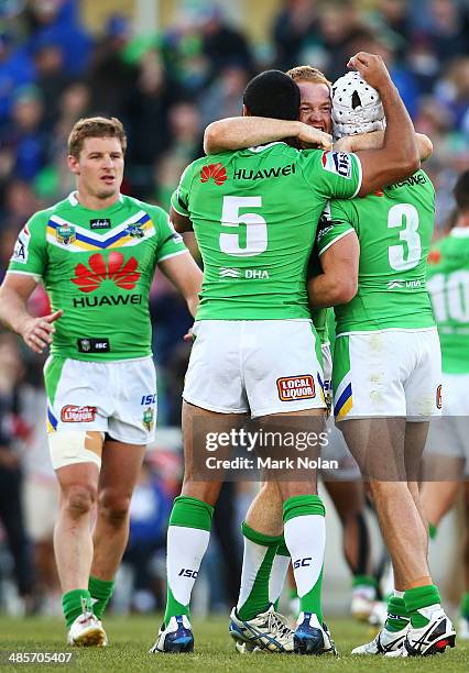 Bill Tupou, Joel Edwards and Jarrod Croker embrace after winning the round seven NRL match between the Canberra Raiders and the Melbourne Storm at...