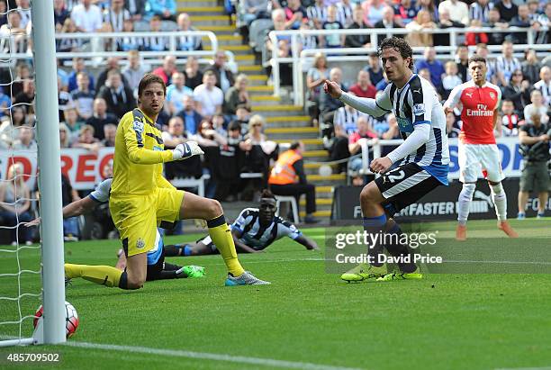 Alex Oxlade-Chamberlain scores Arsenal's goal as Tim Krul and Daryl Janmaat of Newcastle look on during the Barclays Premier League match between...