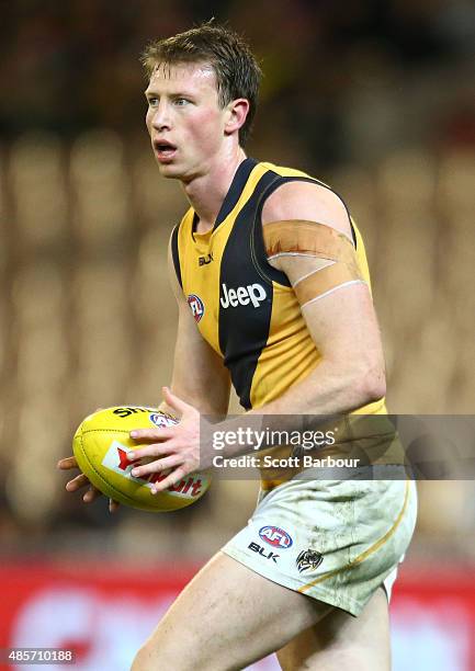 Dylan Grimes of the Richmond Tigers runs with the ball during the round 22 AFL match between the Essendon Bombers and the Richmond Tigers at...