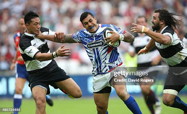 Tusi Pisi of Samoa is tackled by Christian Lealiifano and Jacques Potgieter during the Rugby Union match between the Barbarians and Samoa at the...