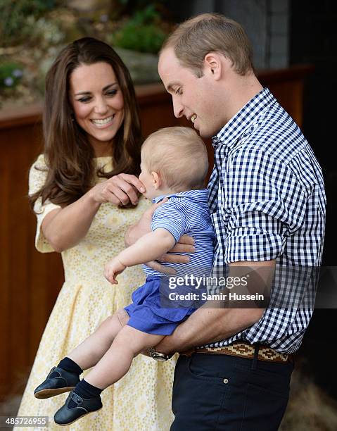 Catherine, Duchess of Cambridge touches the face of Prince George of Cambridge as he is held by Prince William, Duke of Cambridge during a visit to...