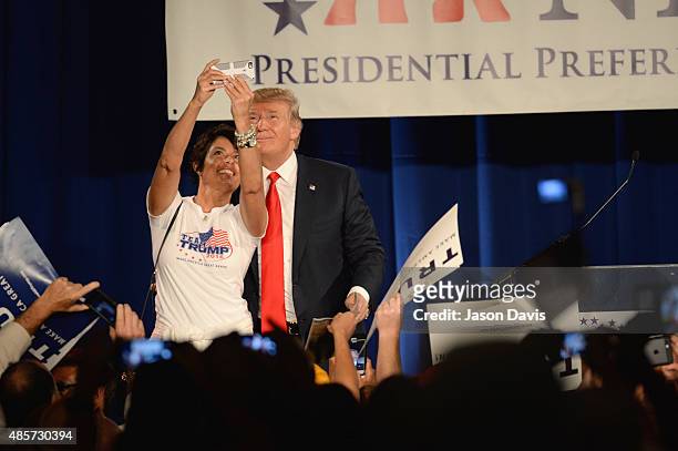 Republican presidential candidate Donald Trump poses for a photo with a woman speaks at the National Federation of Republican Assemblies Presidential...