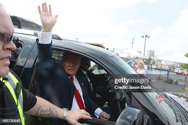 Republican presidential candidate Donald Trump waves from his motorcade as he leave the National Federation of Republican Assemblies Presidential...
