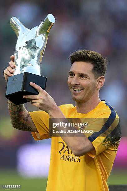 Barcelona's Argentinian forward Lionel Messi lifts up his UEFA Best Player in Europe Award before the Spanish league football match FC Barcelona vs...