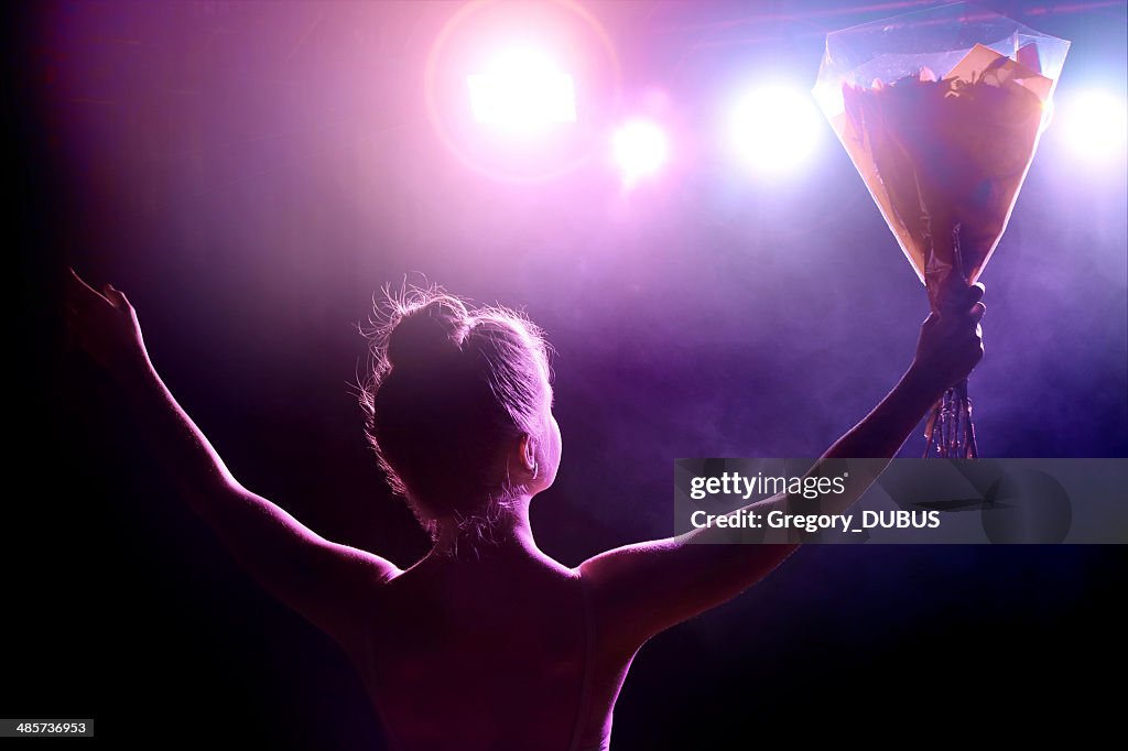 Young artist girl greeting her public after performance on stage