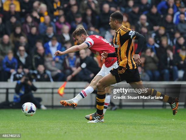 Aaron Ramsey shoots past Hull defender Curtis Davies to socre the 1st Arsenal goal during the Barclays Premier League match between Hull City and...