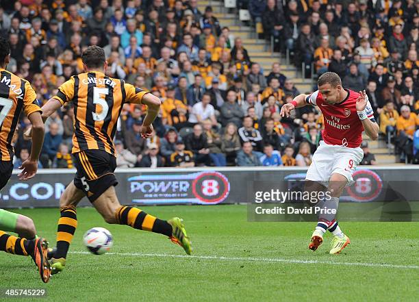 Lukas Podolski scores Arsenal's 3rd goal, his 2nd, as James Chester of Hull closes in during the match between Hull City and Arsenal in the Barclays...