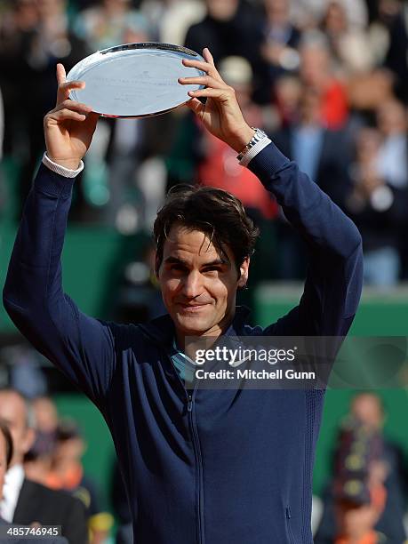 Roger Federerof Switzerland poses with the second place trophy after losing to Stanislas Wawrinka of Switzerland in their final match on day eight of...