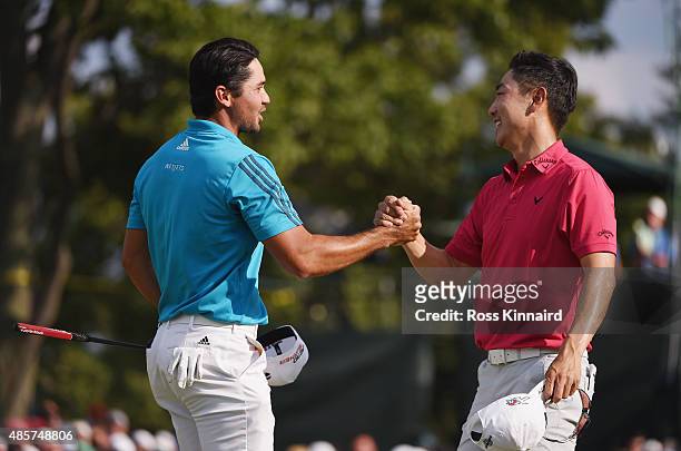 Jason Day of Australia and Sang-Moon Bae of Korea shake hands on the18th green during the third round of The Barclays at Plainfield Country Club on...