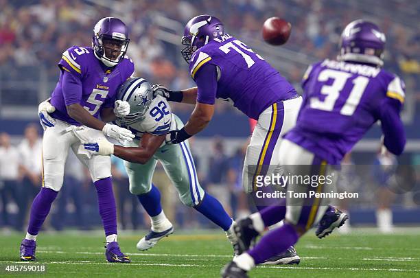 Teddy Bridgewater of the Minnesota Vikings completes a pass turnover Jerick McKinnon of the Minnesota Vikings under pressure from Jeremy Mincey of...