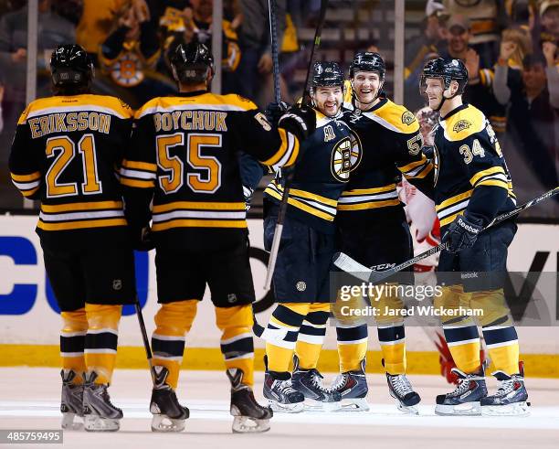 Justin Florek of the Boston Bruins celebrates his goal with teammates Carl Soderberg and Andrej Meszaros in the first period against the Detroit Red...