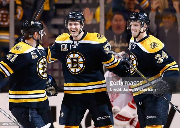Justin Florek of the Boston Bruins celebrates his goal with teammates Carl Soderberg and Andrej Meszaros in the first period against the Detroit Red...
