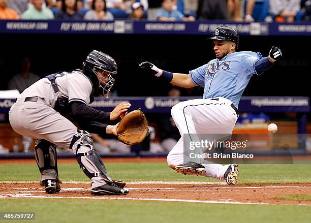 James Loney of the Tampa Bay Rays beats catcher John Ryan Murphy of the New York Yankees to home plate as he scores off of teammate Matt Joyce's...