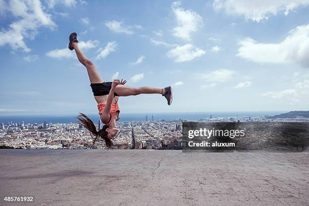 mujer joven practicar parkour en la ciudad de barcelona. - backflipping fotografías e imágenes de stock