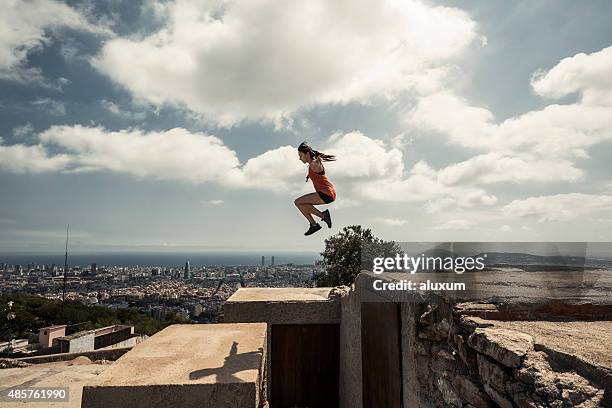 girl jumping and practicing parkour in the city - stunts and daredevils stock pictures, royalty-free photos & images