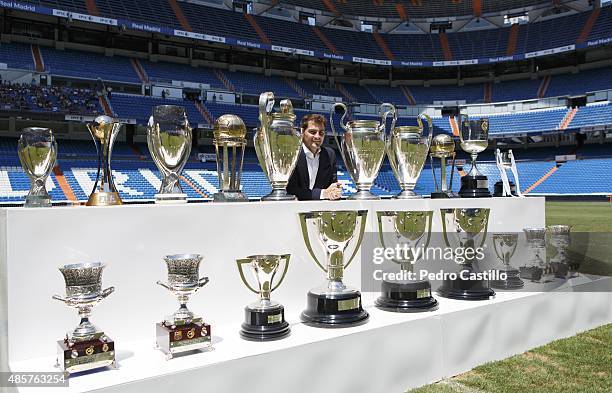 Iker Casillas poses behind trophies he has won during his career in Real Madrid after holding a press conference with Real president Florentino Perez...