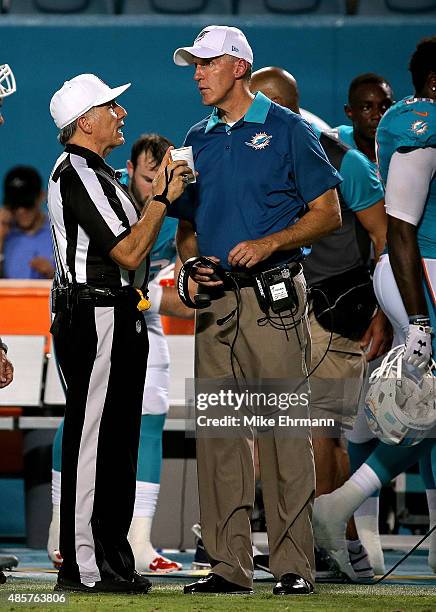 Head coach Joe Philbin of the Miami Dolphins talks with a referee during a preseason game against the Atlanta Falcons at Sun Life Stadium on August...