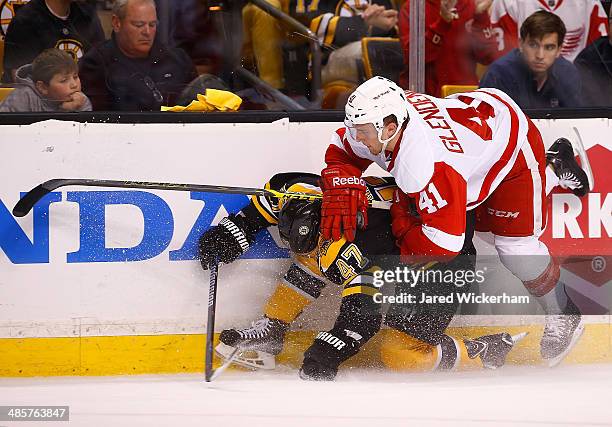 Luke Glendening of the Detroit Red Wings shoves Torey Krug of the Boston Bruins against the boards in the first period during the game at TD Garden...