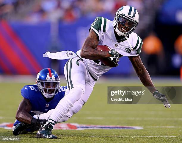 Brandon Marshall of the New York Jets carries the ball as Jeromy Miles of the New York Giants defends during preseason action at MetLife Stadium on...