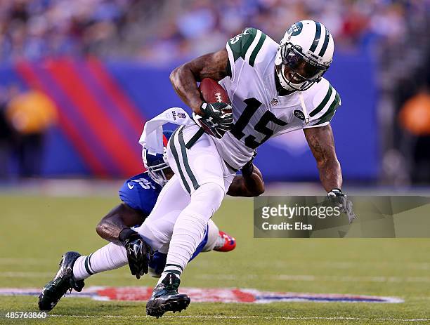 Brandon Marshall of the New York Jets carries the ball as Jeromy Miles of the New York Giants defends during preseason action at MetLife Stadium on...