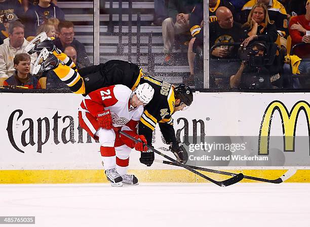 Andrej Meszaros of the Boston Bruins flips over Tomas Tatar of the Detroit Red Wings in the third period during the game at TD Garden on April 20,...