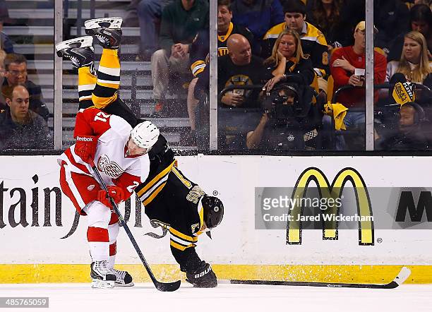 Andrej Meszaros of the Boston Bruins flips over Tomas Tatar of the Detroit Red Wings in the third period during the game at TD Garden on April 20,...