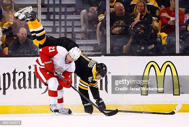 Andrej Meszaros of the Boston Bruins flips over Tomas Tatar of the Detroit Red Wings in the third period during the game at TD Garden on April 20,...