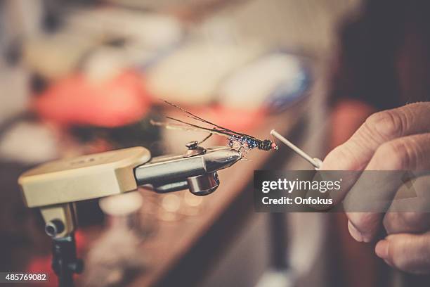 closeup of human hand creating fly fishing lure - tying stock pictures, royalty-free photos & images