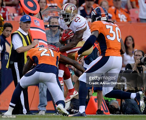 Aqib Talib of the Denver Broncos picks up Reggie Bush of the San Francisco 49ers on a third down stop during the first half of action at Sports...