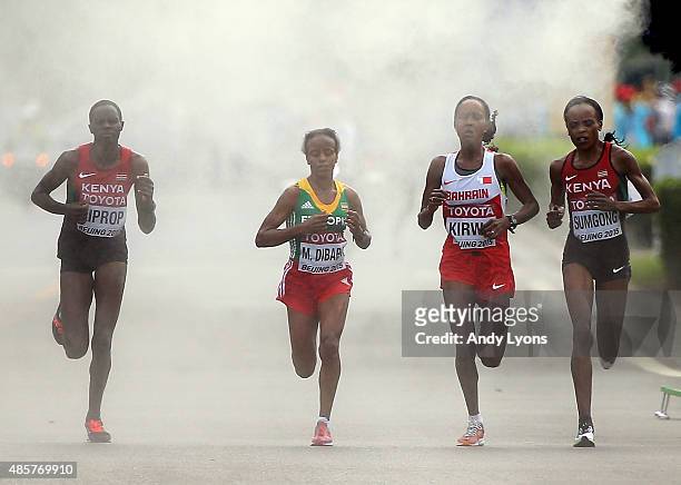 Helah Kiprop of Kenya, Mare Dibaba of Ethiopia, Eunice Jepkirui Kirwa of Bahrain and Jemima Jelagat Sumgong of Kenya run through a misting station...