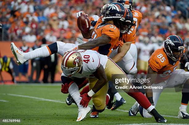 Steve Beauharnais of the San Francisco 49ers forces a fumble on Omar Bolden of the Denver Broncos on the opening kickoff during the first half of...