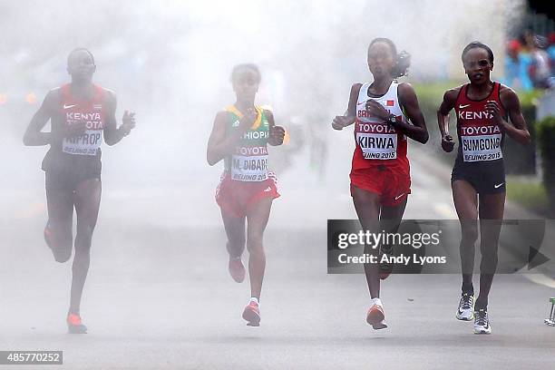 Helah Kiprop of Kenya, Mare Dibaba of Ethiopia, Eunice Jepkirui Kirwa of Bahrain and Jemima Jelagat Sumgong of Kenya run through a misting station...