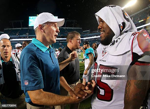 Head coach Joe Philbin of the Miami Dolphins shakes hands with Jonathan Babineaux of the Atlanta Falcons during a preseason game at Sun Life Stadium...