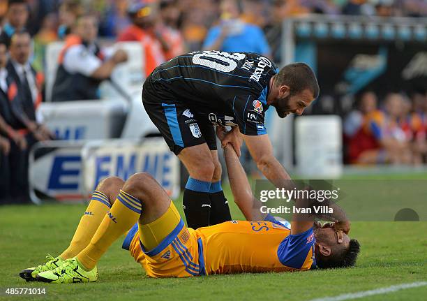 Emanuel Villa talks with Jose Rivas of Tigres during a 7th round match between Tigres UANL and Queretaro as part of the Apertura 2015 Liga MX at...