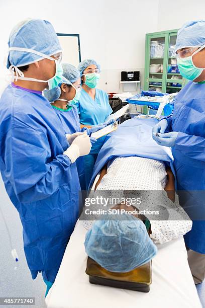 surgical interns taking notes during procedure in operating room - now showing stock pictures, royalty-free photos & images