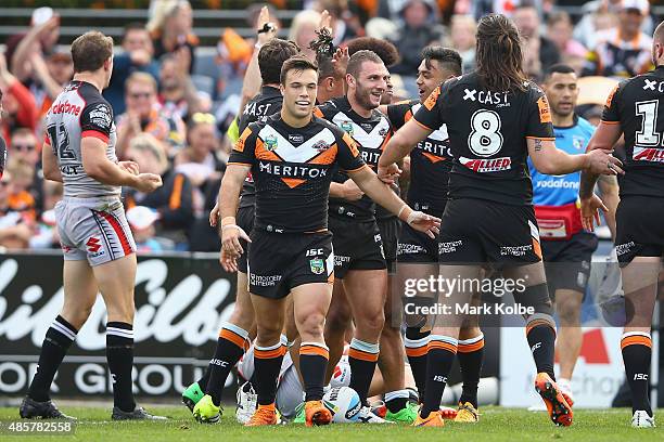Robbie Farah of the Wests Tigers celebrates with his team mates after scoring a try during the round 25 NRL match between the Wests Tigers and the...