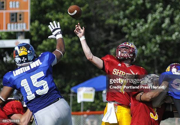 Staff Photo by Shawn Patrick Ouellette: Joseph Seccareccia of Bangor High School throws a pass over the outstretched arms of Trevor Bates of...