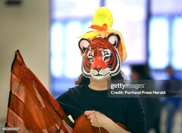 Photo by Tim Greenway/Staff Photographer -- Phyl Rubinstein of North Yarmouth, wearing a tiger mask, helps with the food. Purim is the holiday during...