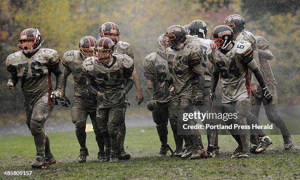 Staff Photo by Shawn Patrick Ouellette: A muddy Bruswick offense makes their way to the line of scrimmage during their game with Mt. Ararat Saturday,...