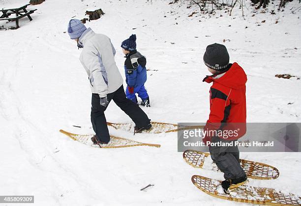 Jill Brady/Staff Photographer: -- Coralie Clement of Kittery and her son, Sylvain MacGovern try out wooden snowshoes while attending the Fort McClary...